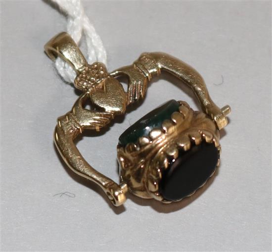 A 9ct gold and chalcedony set spinning fob with clasped hands motif.